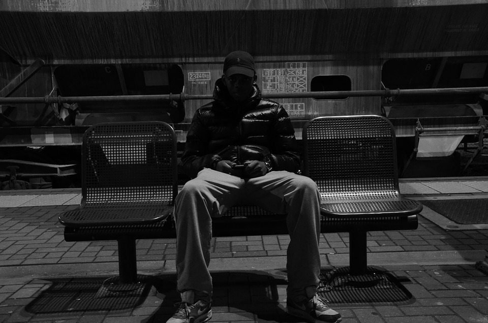 man wearing jacket sitting in a bench