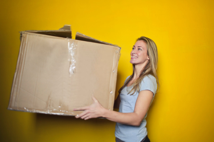a woman holding a big box